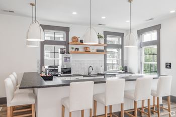 Clubhouse kitchen with white chairs and a marble counter top at Wynfield apartments in York, PA